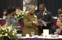 Barbara Seals Nevergold is handed the Education Award by Alphonso O'Neil-White.