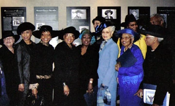 Uncrowned Queens members and other people at the Uncrowned Queens in Their Hats exhibit.