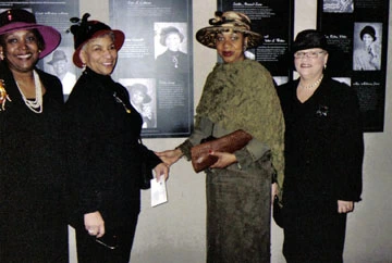 Uncrowned Queens members and other people at the Uncrowned Queens in Their Hats exhibit.