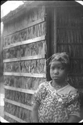Young girl in front of straw wall.
