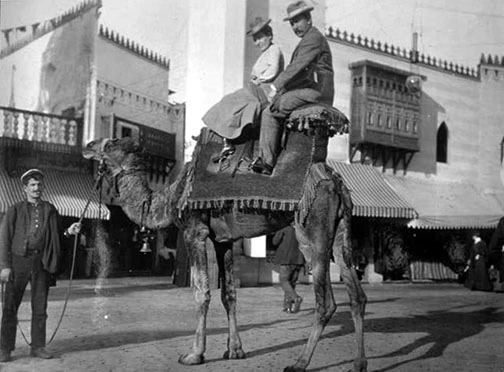 A couple riding a camel.