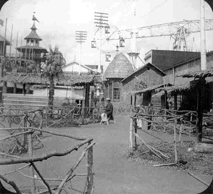 An African village, with metal structures and powerlines in the background.