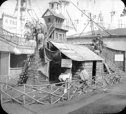 An African village, with metal structures and power lines in the background.