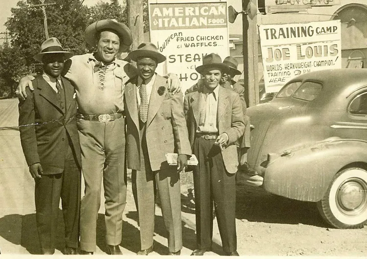 Identity of other men is unknown, but note the sign which identifies site as Joe Lewis Training Camp